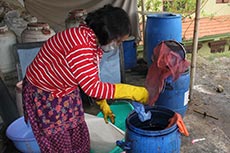 Frau beim FÃ¤rben von Loktapapier Nepal